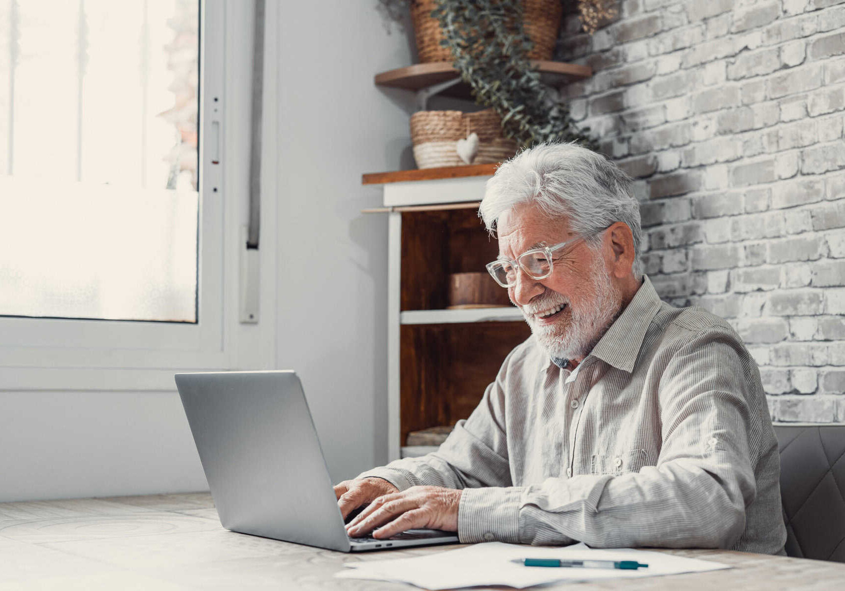 Man smiling while using a laptop